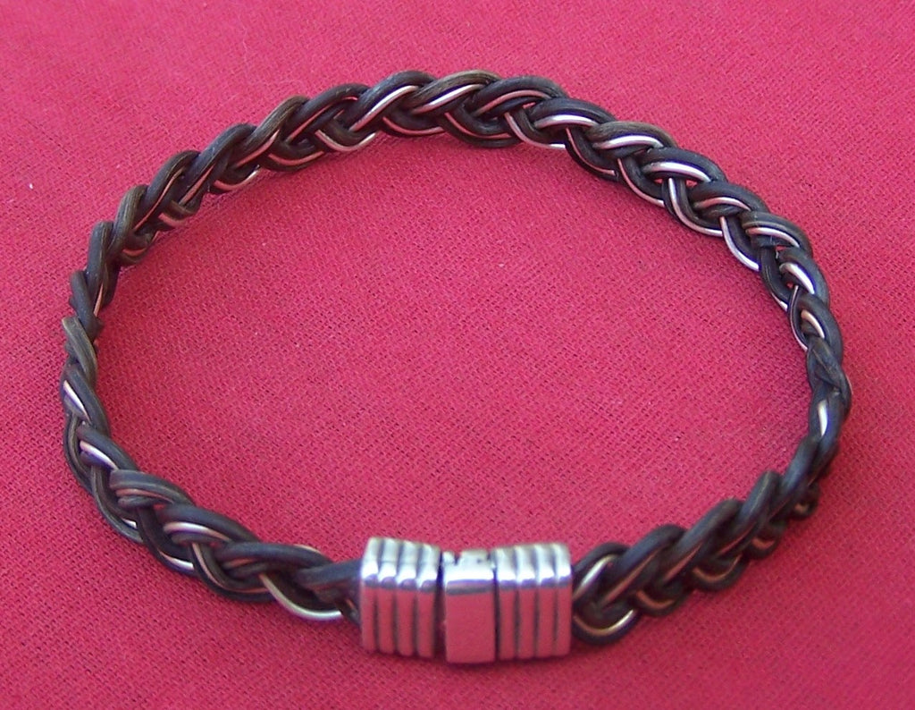 Two parts dark elephant hair with one part sterling silver filament are woven into this braided marvel. A lovely sterling silver clasp finishes the design nicely. - JEPP